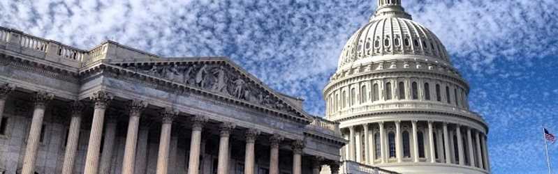 Image of the United States Capitol with sky and clouds in the background.
