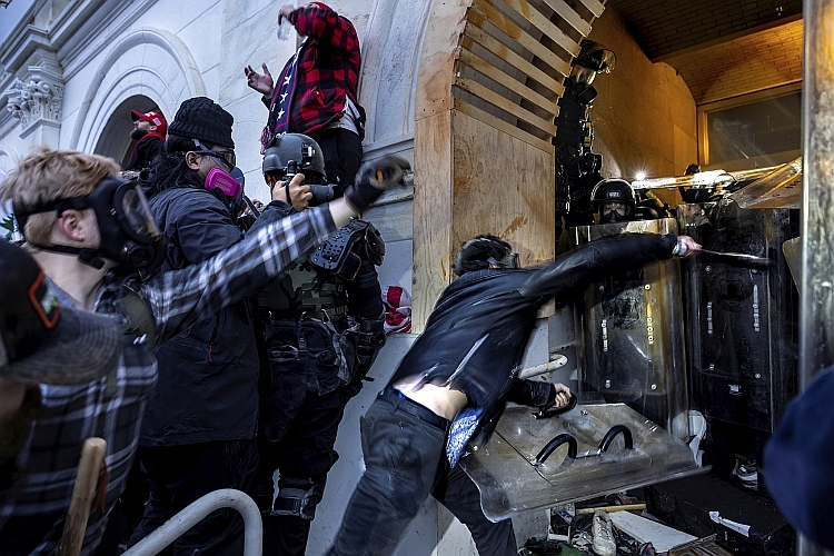 Rioters assault police officers at a tunnel to the Capitol.