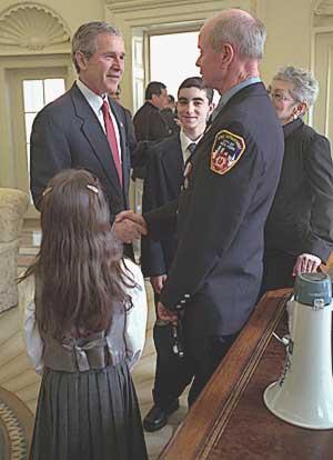 President Bush greeting firefighter Bob Beckwith after receiving the Ground Zero bullhorn in the Oval Office, February 25, 2002
